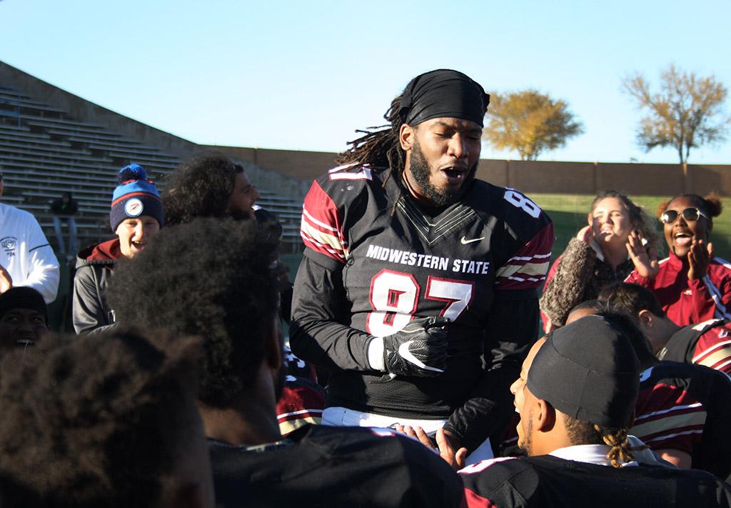 Dorian Johnson, kinesiology and sports and leisure senior, gives a shout out at the beginning of the group huddle after MSU shook hands with University of Sioux Falls players after the Round One NCAA II Playoff game where MSU won 24-20. Photo by Rachel Johnson
