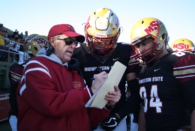 Head Football Coach Bill Maskill discusses plays with players Alec Divalerio, exercise physiology junior, and Mitchell Henton, mechanical engineering senior, during the last 5 minutes of the fourth quarter during the Round One NCAA II Playoff game against University of Sioux Falls at Memorial Stadium, Saturday Nov. 18, 2017. Photo by Rachel Johnson