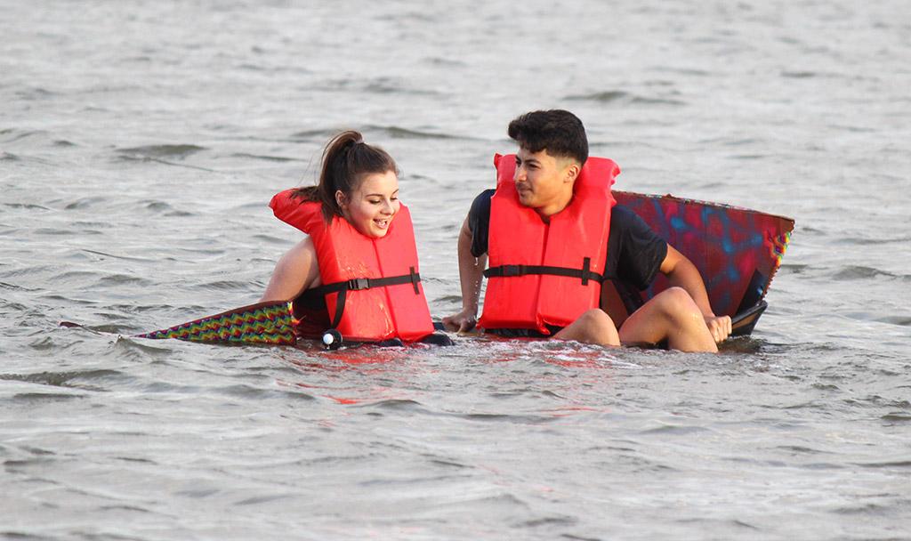Javier Suarez, mass communication sophomore, and MIa Heck, mass communication sophomore, rest on their sinking boat for Chi Omega and Sigma Alpha Epsilon during the Homecoming Boat Race Friday Oct. 20, 2017. Photo by Rachel Johnson