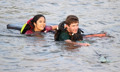 Kale Hutchins, general business freshman, and Andrea Mirasol, undecided freshman, swim their way back to shore with their sunken boat after only getting about 20 feet out before their ship collapsed on them during the Homecoming Boat Race 2017. Photo by Rachel Johnson