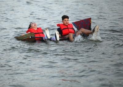 Mia Heck, mass communication sophomore, and Javier Suarez, mass communication sophomore, try to cross Sikes Like in their boat for Chi Omega and Sigma Alpha Epsilon. Their boat failed about 50 feet from the starting line. Photo by Bradley Wilson