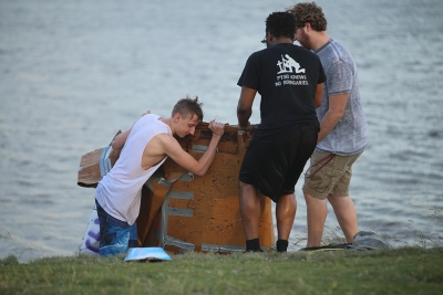 Luke Sanders, psychology senior, and Aaron Devaul, psychology senior, pull their boat from the water after the homecoming cardboard boat race on Sikes Lake Oct. 20, 2017. Photo by Bradley Wilson