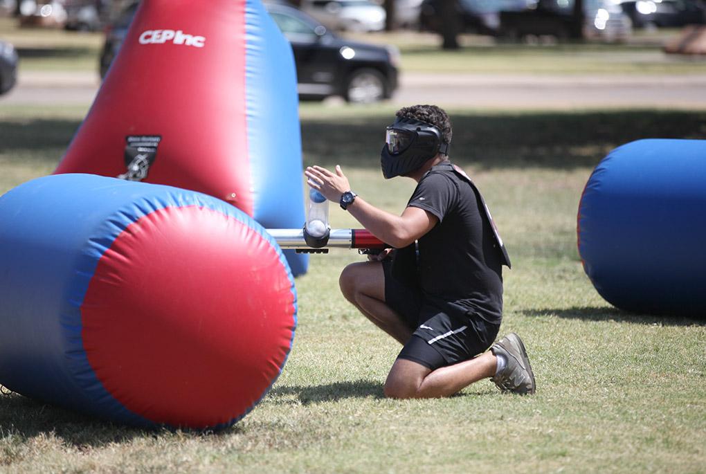 While Elam Lazo, nursing sophomore, reloads his air cannon with foam balls, he hides behind a obstacle to avoid getting shot by the other team, during a game of Bongo Ball, held in the quad, Sept. 9. Photo by Rachel Johnson