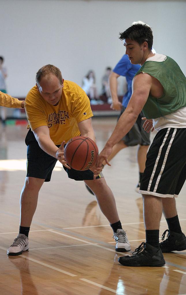 Dennis Roeder, finance senior, reaches out to grab the ball, after dropping it, as Coleman James, undecided sophomore, goes for the ball as well during the Chi-Omega Basketball Tournament, Swishes for Wishes, Sat. March 28, 2015. Photo by Rachel Johnson