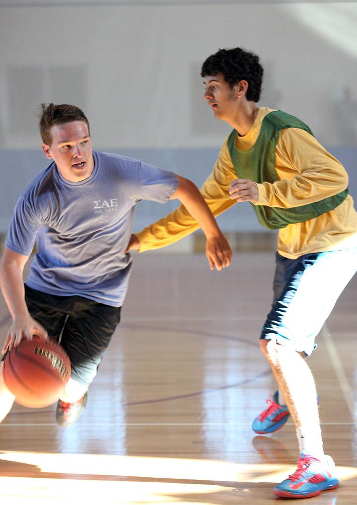 Grant Boxell, finance sophomore, dribbles around Luke Davis, criminal justice freshman, to go up for the shot during the Chi-Omega Basketball Tournament, Swishes for Wishes, Sat. March 28, 2015. Photo by Rachel Johnson