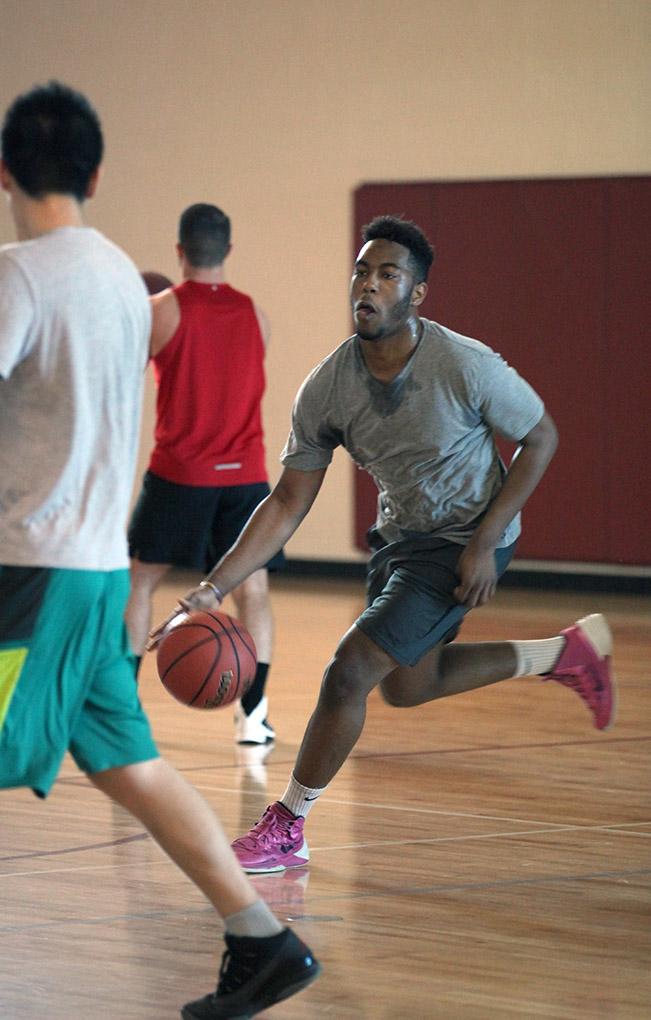 Gerald Ezendu, nursing sophomore, dribbles the ball down the court to make a layup, during the  Chi-Omega Basketball Tournament, Swishes for Wishes, Sat. March 28, 2015. Photo by Rachel Johnson