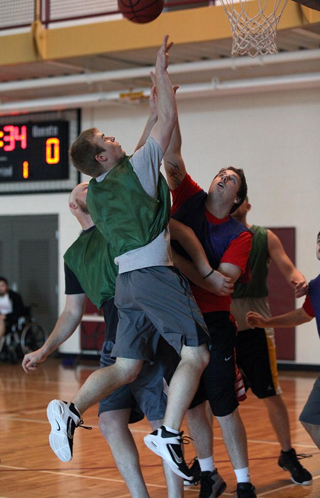 Bradley Anderle, Lawyer, goes up for a layup and make it as his teammate, Cody Anderle, engineer, blocks a member of the opposing team during the  Chi-Omega Basketball Tournament, Swishes for Wishes, Sat. March 28, 2015. Photo by Rachel Johnson