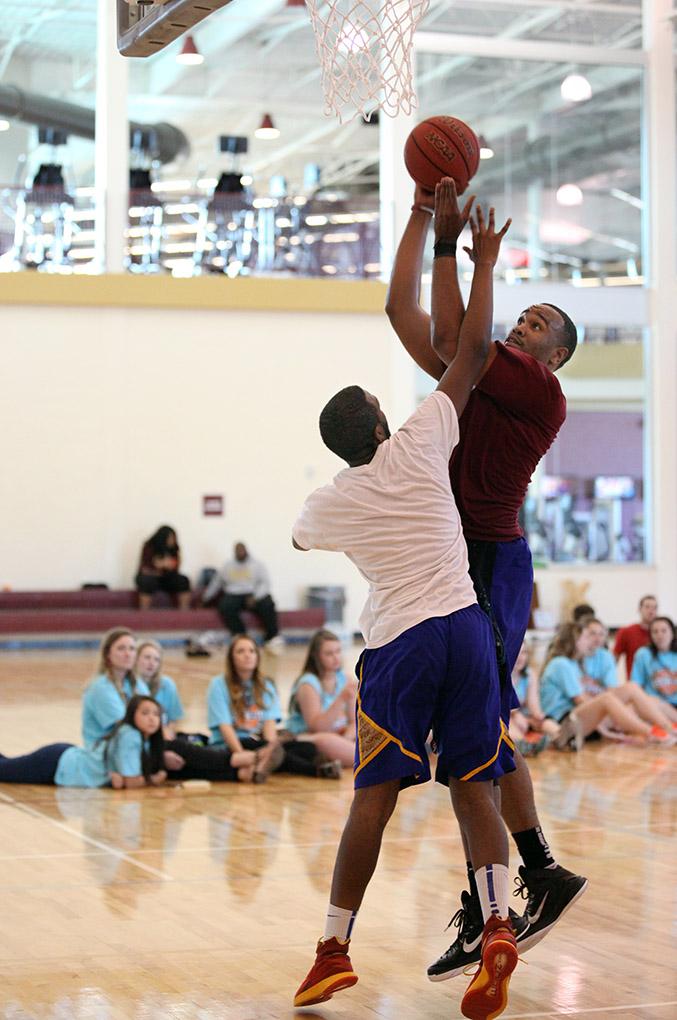 Matthew Scott, graduate assistant for basketball coach, goes up for the shot as Alonzo Burris, athletic training freshman,  attempts to block it during the championship game of the Chi-Omega Basketball Game, Swishes for Wishes, Saturday, March 28, 2015. Fab 5 beat Sticky Bandits 27-10. Photo by Rachel Johnson