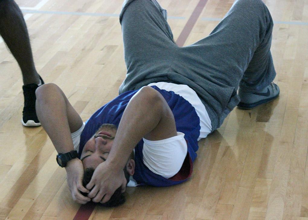 Elam Lazo, nursing freshman, grabs his head, while in pain due to a leg injury during the Chi-Omega Basketball Tournament, Swishes for Wishes, Saturday, March 28, 2015. Elam said, "Just to play."  Photo by Francisco Martinez