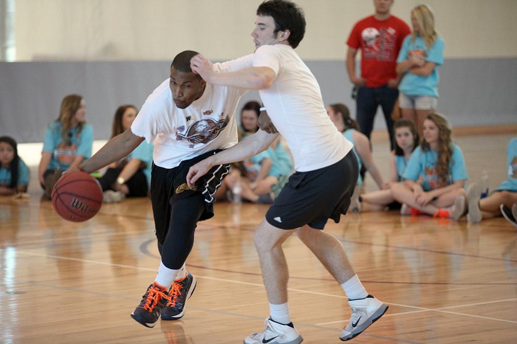Andre Shaw, grad assistant coach, dribbles past Zach Davis, history sophomore,  who tries to block him, during the Chi-Omega Basketball Tournament, Swishes for Wishes. Fab 5 beat Sticky Bandit, 27-20, in the championship game,  Saturday, March 28, 2015. Shaw said, "We did it to give back, bring back unity to the school, and help a good cause."  Photo by Francisco Martinez