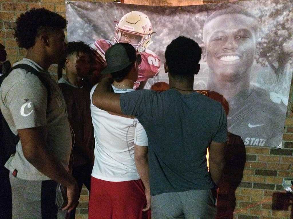 Football players honor injured player at the community gathering. Photo by Bradley Wilson