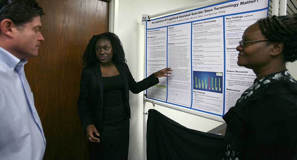 Shirley Hazel, sociology senior, and Careisha Whyte, accounting and sociology senior, present their research on legalized assisted suicide during EUREKA on April 27. Photo by Arianna Davis