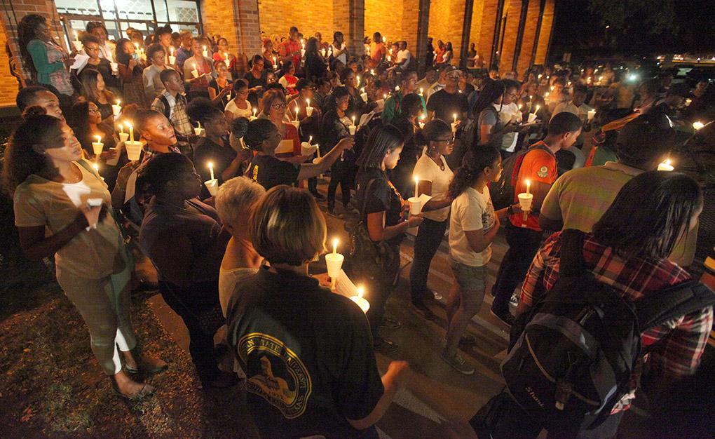 Students and others gather outside of Bolin Hall with candles to honor the victims of the remnants of tropical storm Erika Sept. 1. Photo by Francisco Martinez