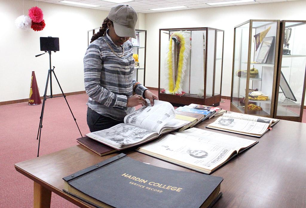 Rolanda Ferdinand, general business senior, looks through the old Wai-Kun and Wichitan editions that were scanned onto the MSU HIstory Display, which is on the second floor of the Moffett Library, and was unveiled Feb. 9. Photo by Rachel Johnson