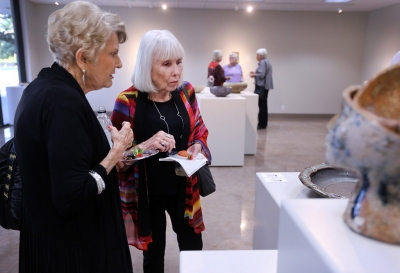 Anne-Marie Williamson, artist in Empty Bowls, and Lee Williamson, her son, look at the other bowls that were entered into the Empty Bowls Gallery Oct. 5 before the juror announces the winner of the competition. Photo by Rachel Johnson