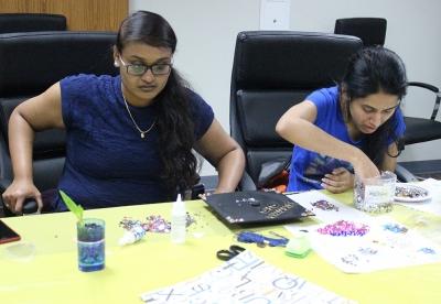 Tejaswi Singam, computer science masters, and Tejaswini Wootkuri, computer science masters, decorate their caps for graduation during Finals Frenzy, Thurs. Dec. 7, 2017. Photo by Rachel Johnson