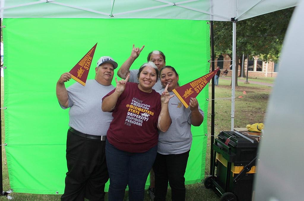 Rutth Mercado, biology sophomore, and Juan Mercado, sociology junior, get their picture taken with their parents, Araceli Marcado and Juan Mercado, at one of the photo booths set up in the Quad for Family Day, Sept. 26. Photo by Rachel Johnson