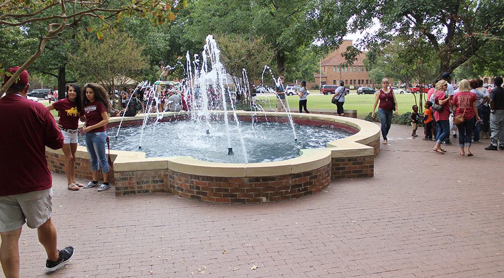 People walk around and sit near the Bolin Fountain, talking with friends and family or waiting to go to the next activity on Family Day, Sept. 26. Photo by Francisco Martinez