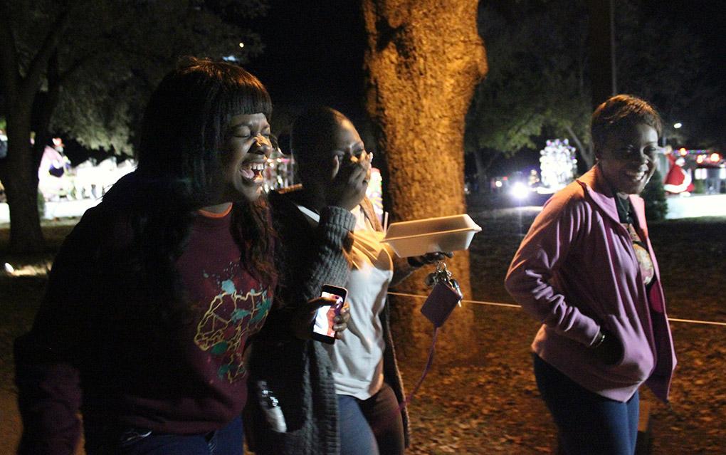 Lisa Nyirenda, accounting sophomore, Roylyka Roache, english junior, and Kedisa Alexander, acccounting senior, laugh and make memories as they walk through the Fantasy of Lights at the Opening Ceremony on Monday night infront of the Hardin Building. Photo by Rachel Johnson