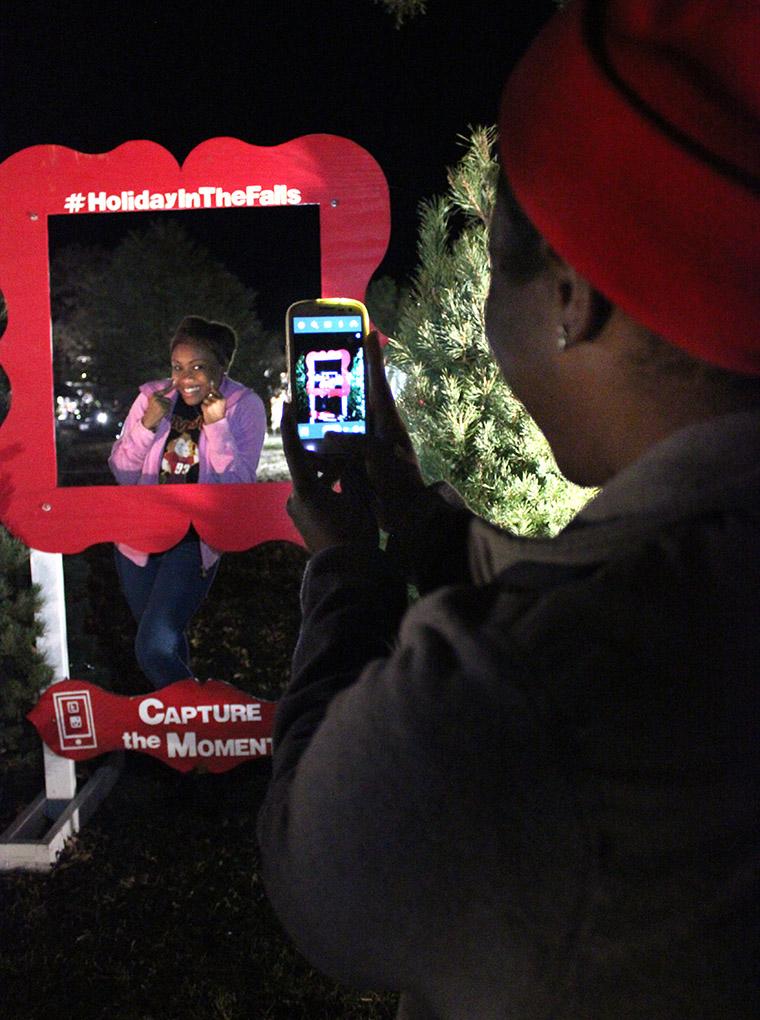 Ariel Douglas, finance senior, takes Kedisa Alexander's, accounting senior, picture during the Fantasy of Lights Opening Ceremony, Monday night infront of the Hardin Building. "My favorite thing of Fantasy of Lights, aside from the lights, is just the people and being with friends and the memories we make. And everyone here just seems so cheerful and happy," Alexander says at her first time attending this. Photo by Rachel Johnson
