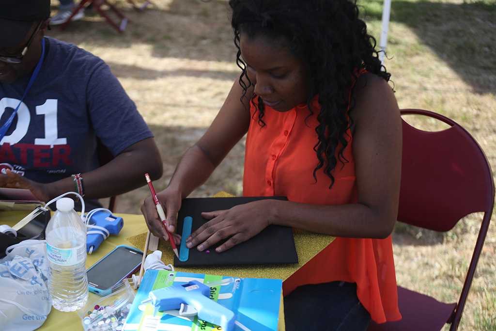 Akeida Alexis, 2017 graduate, makes the outlines for her graduation cap design at the spring Finals Frenzy on the Jesse Rodgers Promanade on May 4, 2017. Photo by Timothy Jones