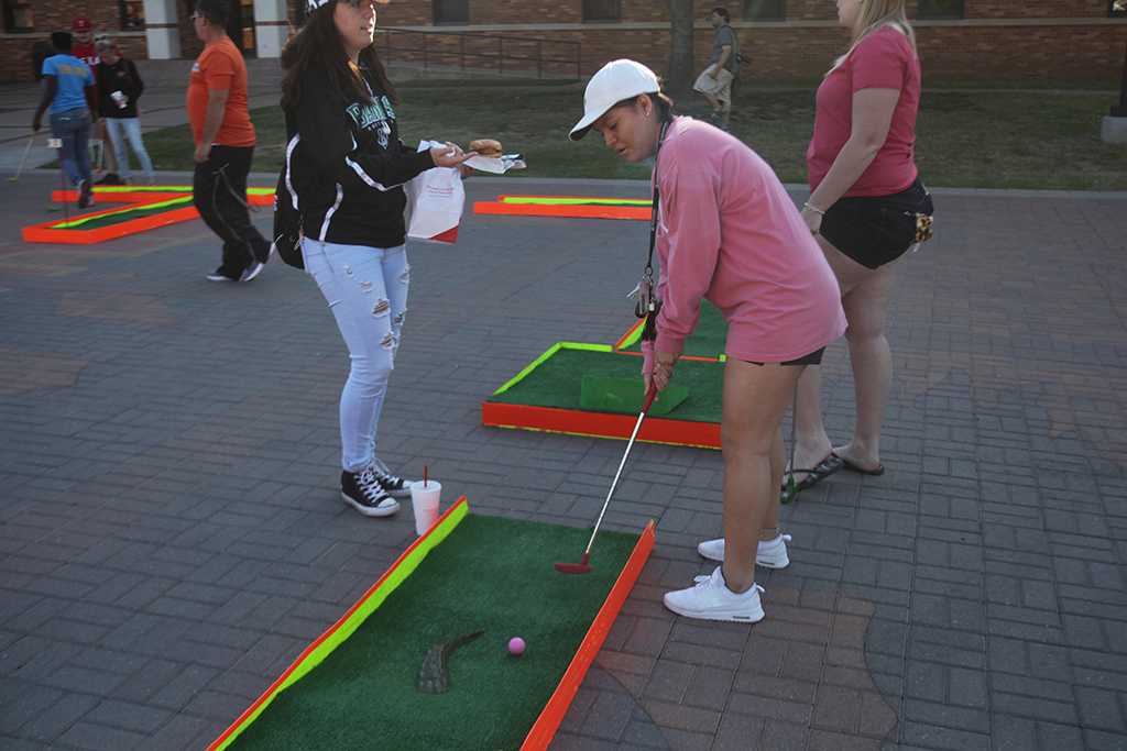 Maley Villanueva, dental hygeine sophomore, tees up on the mini golf course at the spring Finals Frenzy on the Jesse Rodgers Promanade on May 4, 2017. Photo by Timothy Jones
