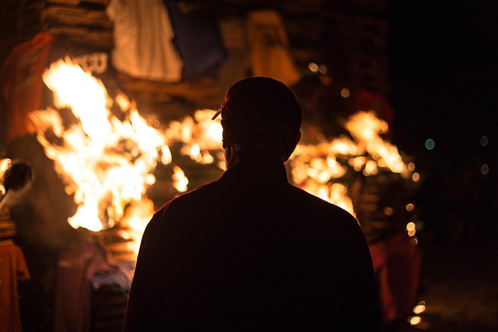 Head football coach Bill Maskill lights the bonfire on Oct. 27. Photo by Izziel Latour