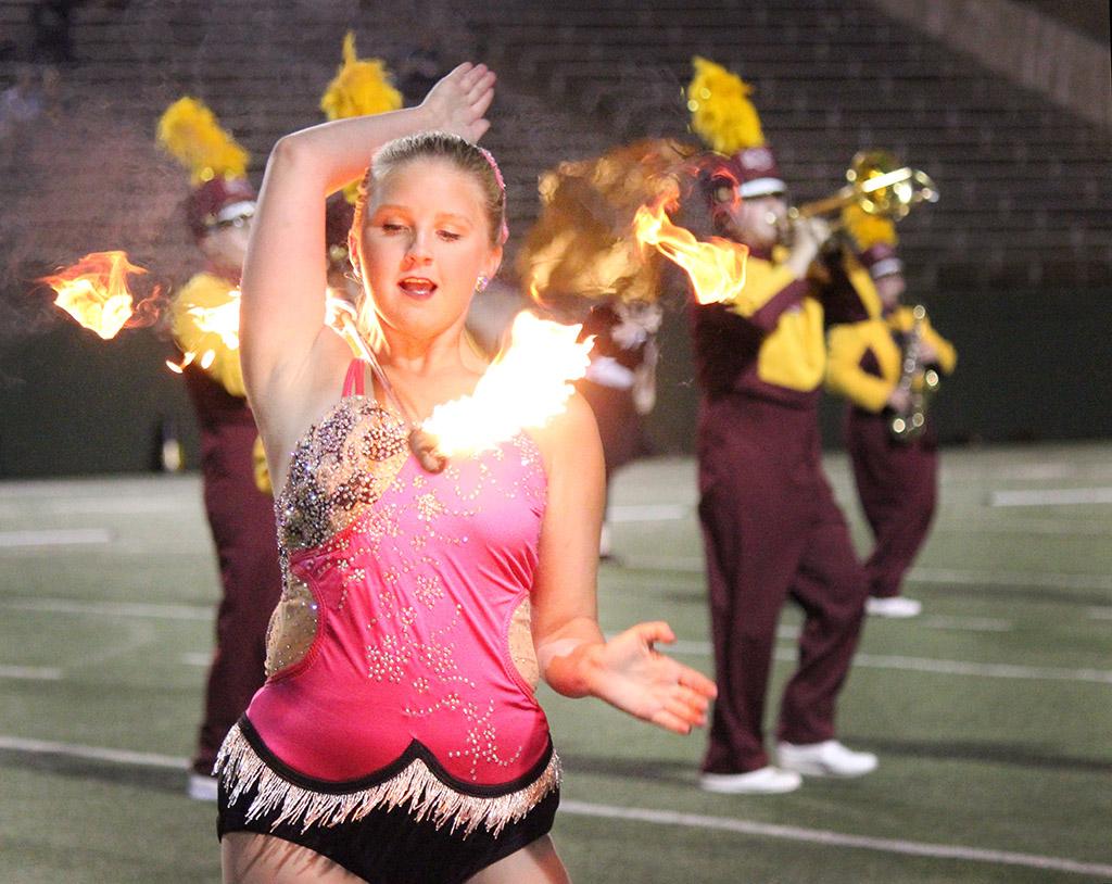 Alexis Maggard, special education freshman, twirls her baton that is on fire around her shoulders as a part the Golden Thunder Marching Band's halftime performance titled 'Changing Channels' Oct. 7. Photo by Rachel Johnson