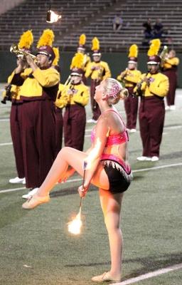Alexis Maggard, spech education freshman, shows off her hair ribbon while she tosses her lit batons in the air as the band performs "Changing Channels" for the Texas A&M Commerce vs MSU football game held at the Memorial Stadium, Oct. 7. Photo by Marissa Daley