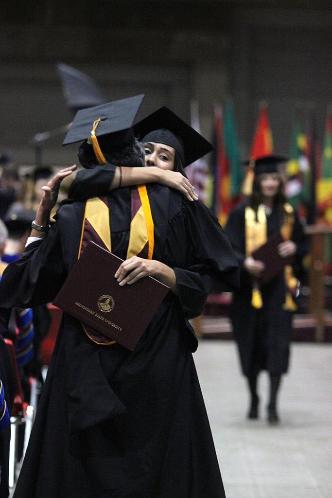 A student and a profesor hug after the student walked across the stage at Midwestern State University fall graduation, Dec. 13, 2014 in Wichita Falls, Texas. Photo by Rachel Johnson
