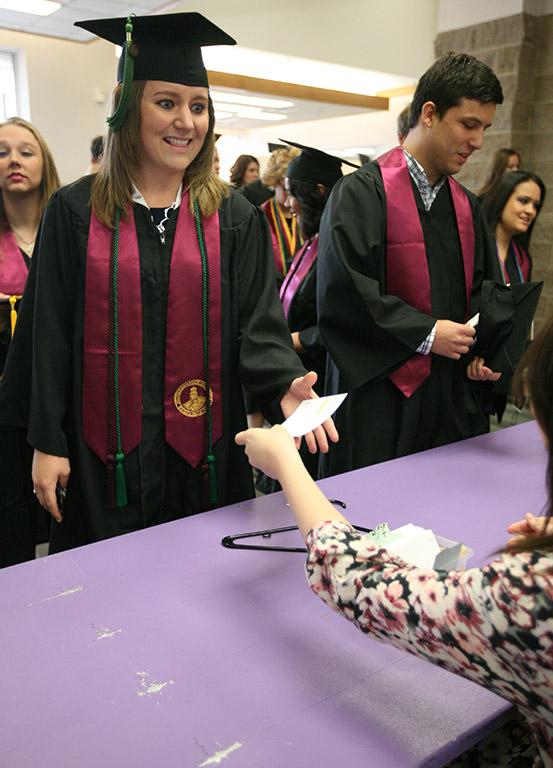 Jylann Trammell, radiology, gets her card to fill out, after checking in before Commencement in the MPEG, at May 14. Photo by Rachel Johnson