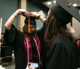 Mae Johnson, nursing, gets help from Deborah Roucloux, nursing, to fix her cap while waiting for Commencement to start at the MPEG, May 14. Photo by Rachel Johnson