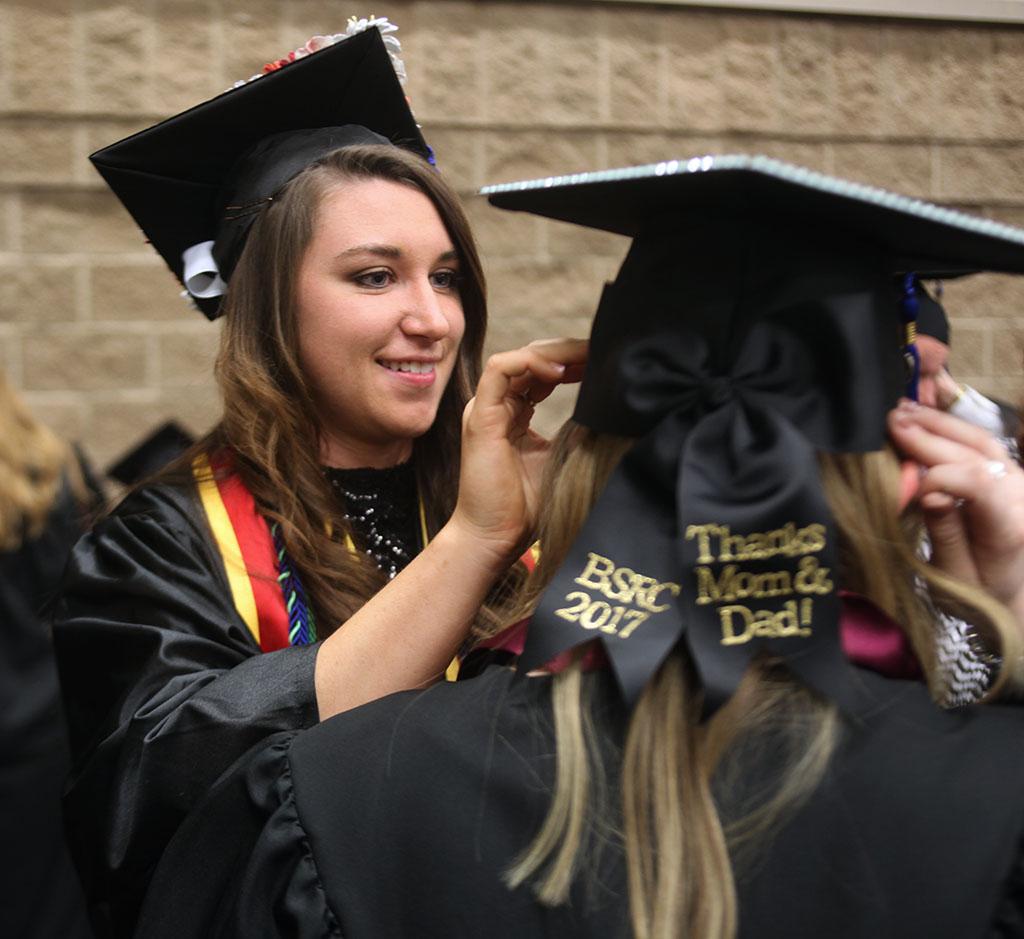 Emma Davenport Respiratory Care graduate helps fellow Respiratory Care graduate put on graduation cap.Midwestern State University Commencement Cermemony, Kay Yeager Coliseum.May 14th.by Timothy Jones