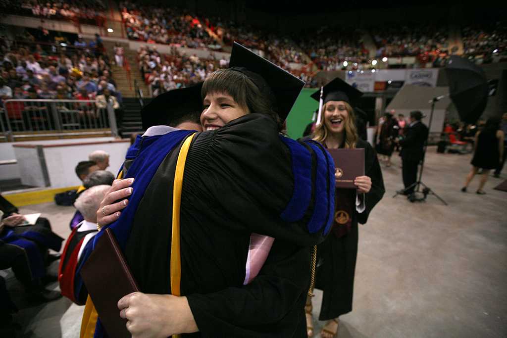 Megan Piehler hugs mass communication associate professor Jim Sernoe at Midwestern State University graduation, May 13, 2017. Photo by Bradley Wilson