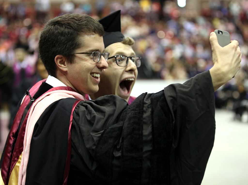 Lee Finnings, music graduate, snaps a quick selfie with Gordon Hicken, assistant professor of music and director of bands, after receiving his certificate at Midwestern State University graduation, May 13, 2017. Photo by Timothy Jones