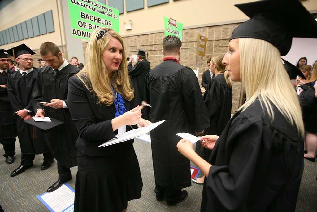 Rachel Bullard, graduation usher and theater junior, helps Kaitlyn Whatley, accounting graduate, find her place in line at Midwestern State University graduation, May 10, 2014. Photo by Ethan Metcalf