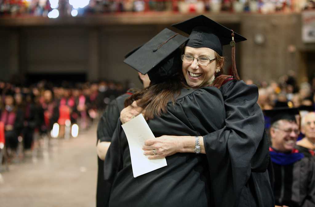 Laura Jefferson, associate professor of theater, hugs a student at Midwestern State University graduation, May 10, 2014. Photo by Ethan Metcalf