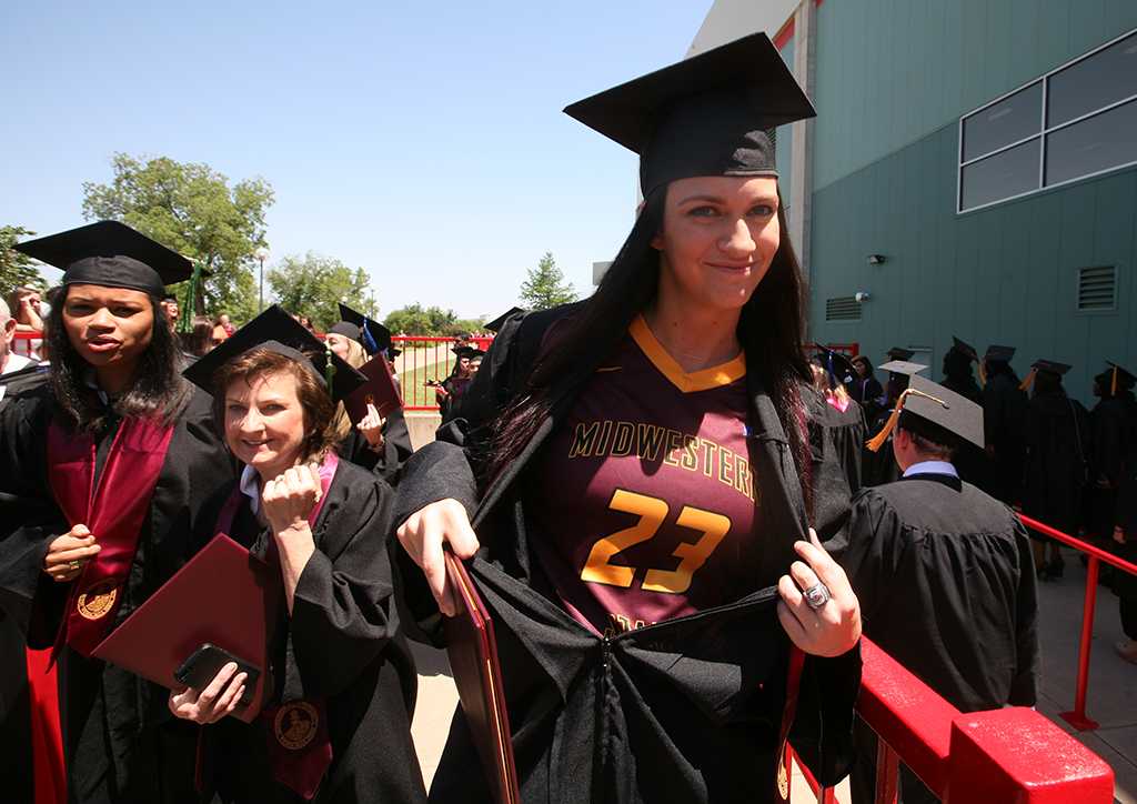 Skylar Warrick, mass communication graduate, shows off her hidden basketball jersey after leaving the MPEC at Midwestern State University graduation, May 10, 2014. Photo by Ethan Metcalf