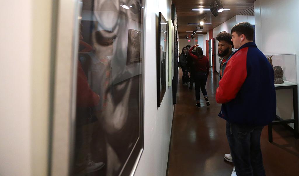 Rozarious Bell, a senior at Sabine High School, and Jacob Keifer, also a senior at Sabine High School, look at artwork before the opening of the MWSU High School Art Show, Feb. 3, 2018. Photo by Treston Lacy
