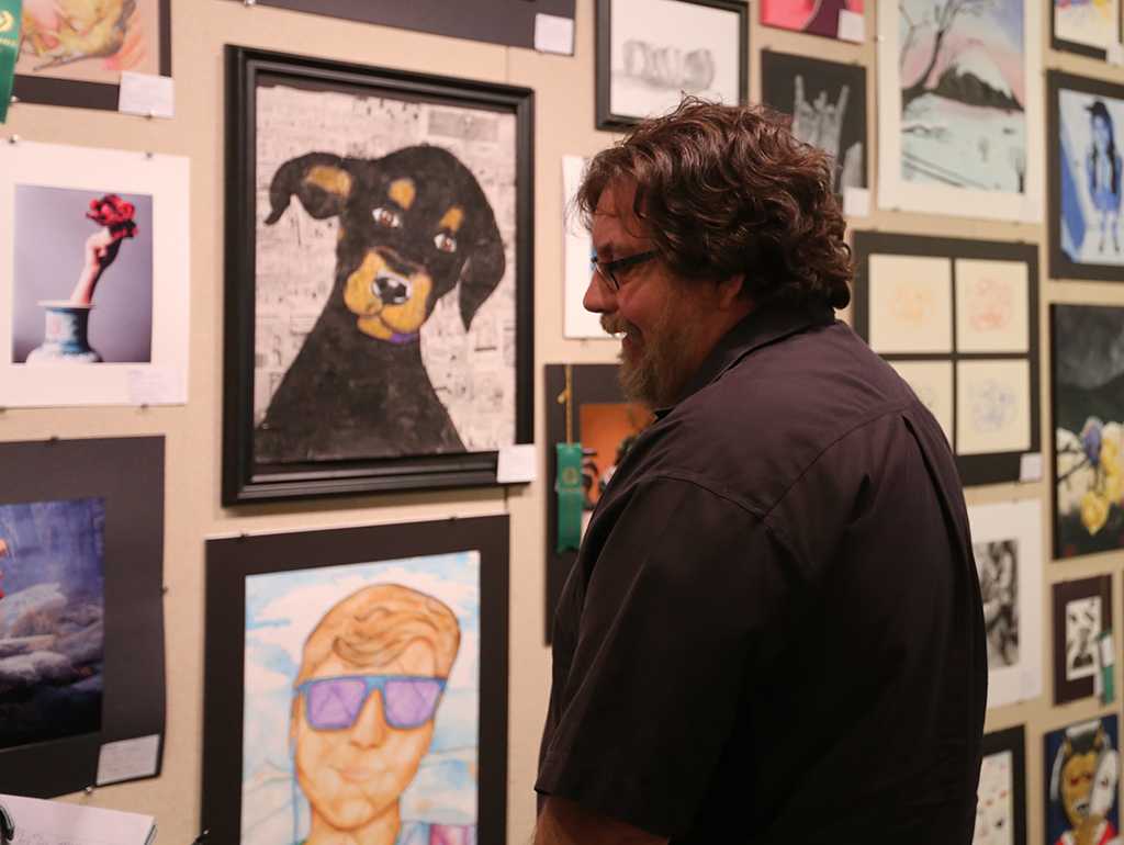 From Lewisville, Andy Longo, whose daughter compete in the show, looks at artwork at the opening of the MWSU High School Art Show, Feb. 3, 2018. Photo by Treston Lacy