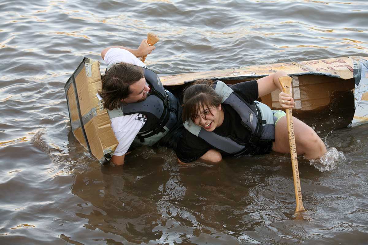 Christian Estep and Gloria Villarreal, biology senior, at the cardboard boat race in Sikes Lake Oct. 24, 2014. Photo by Bradley Wilson