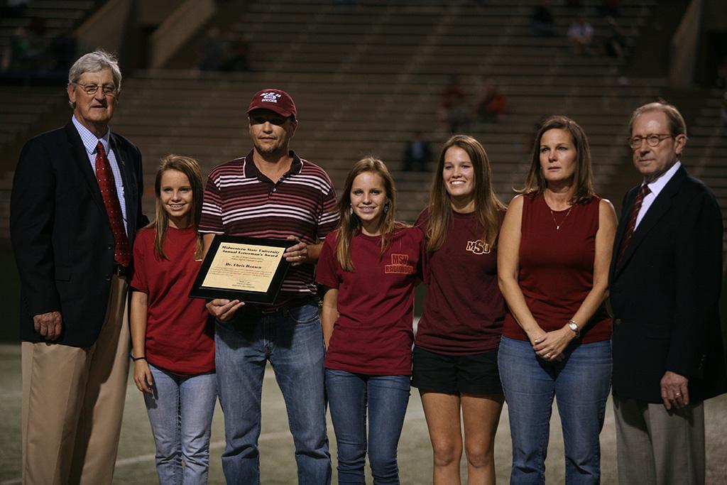 Associate Professor of Chemistry Chris Hansen receives his recognition as the Annual Letterman's Award from the student athletes at the homecoming game, Oct. 25, 2015. Photo by Bradley Wilson