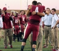 JakeGlover, accounting senior, hugs Adam Austin, Assistant Football Coach and Offensive Coordinator, as he walks down the line of his teammates for his last College football game. It was the 2014 Homecoming game Saturday night at Memorial Stadium, Sabina Marroquin, history education senior, won 2014 Homecoming Queen and Elijah wire, sport and leisure studies senior, won 2014 Homecoming King. Photo by Rachel Johnson