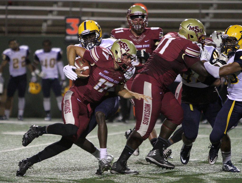 Hagen Hutchinson, kinesiology freshman, is tackled in the game between Midwestern State University and Texas A&M-Commerce, Saturday, Oct. 25, 2014 at Memorial Stadium. Photo by Lauren Roberts