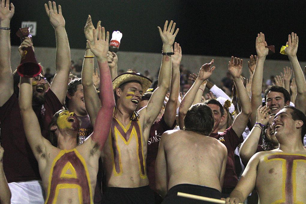 Members of the stanggang raise their hands and cheer at the game between Midwestern State University and Texas A&M-Commerce, Saturday, Oct. 25, 2014 at Memorial Stadium. Photo by Lauren Roberts