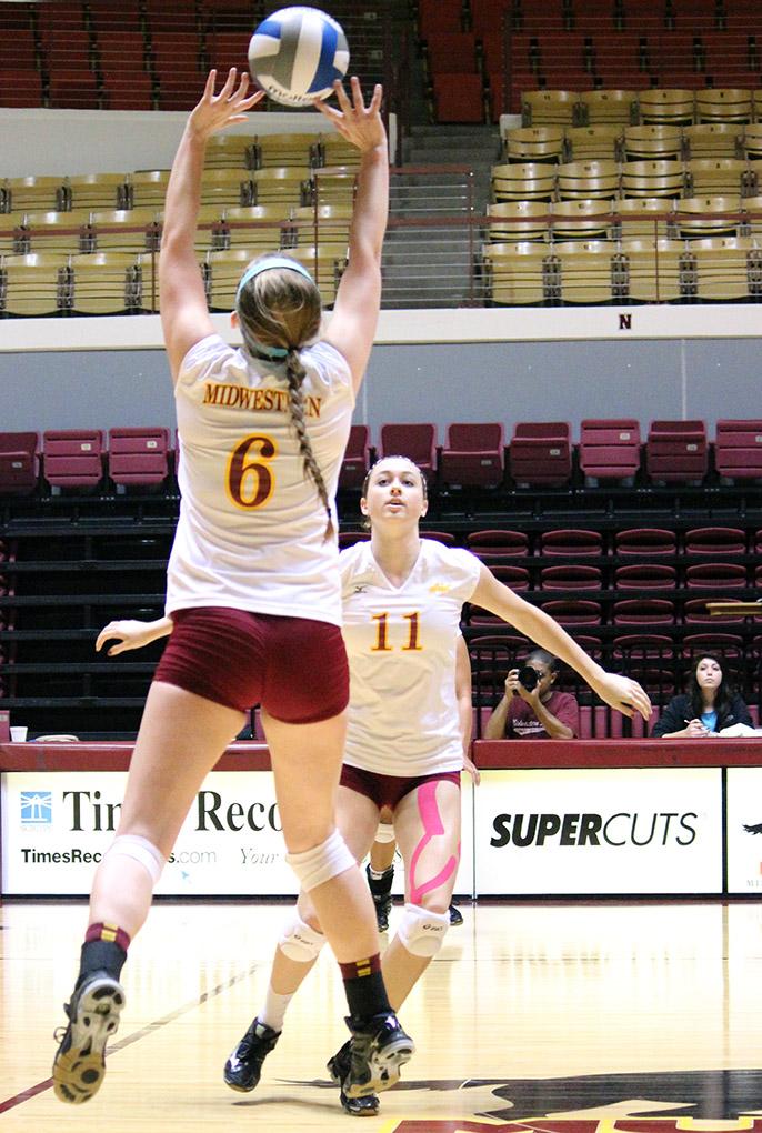 Sarah Rosinke, pre-medicine sophomore, sets the ball up for Sarah Garfield, education and business sophomore to spike to the other side at the D.L Ligon Coliseum on Saturday afternoon against Texas Women's University. Photo by Rachel Johsnon