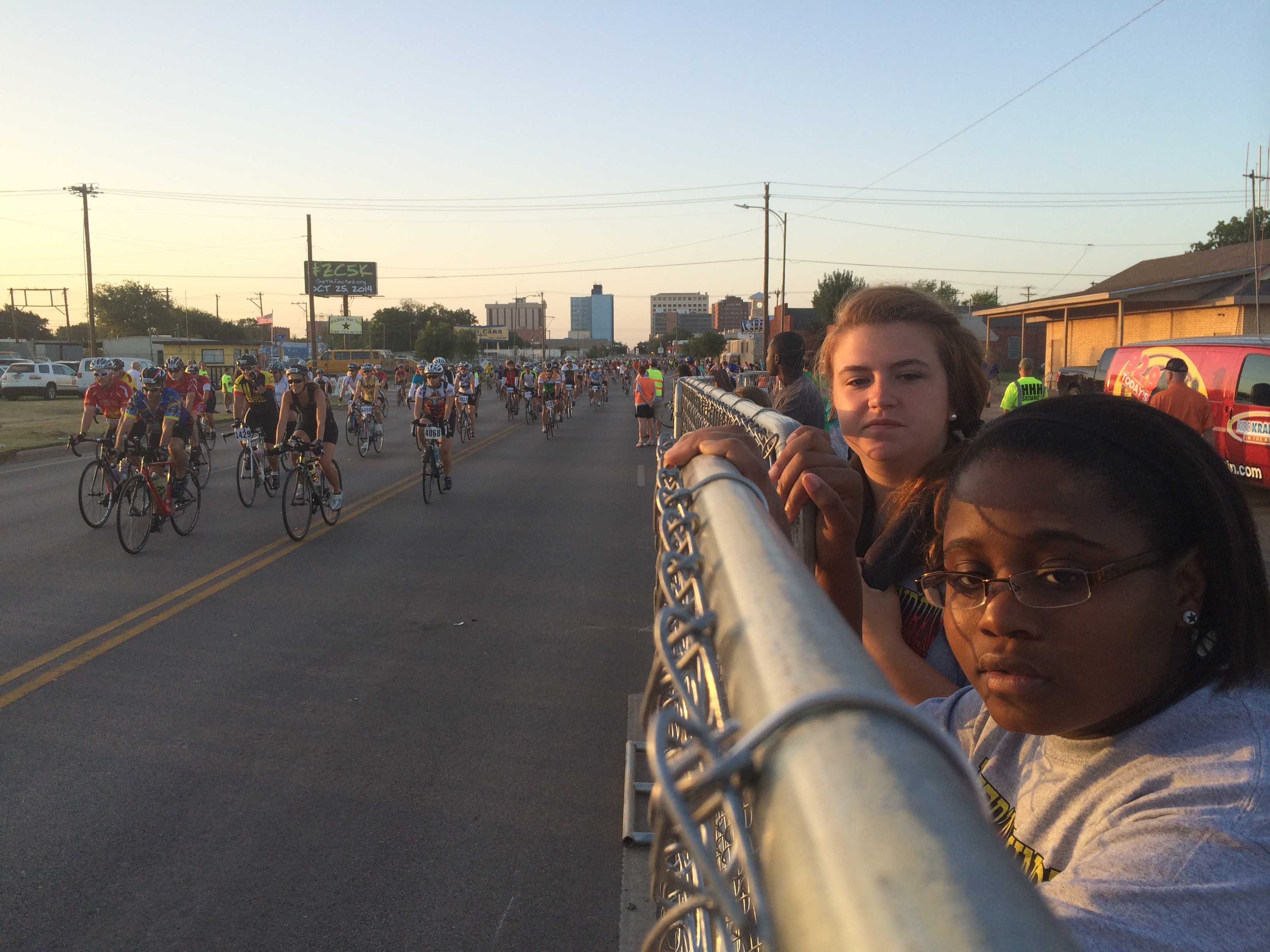 Macy Pritchett, education sophomore, and Talia Harris, mass communication sophomore, watch the endless stream of racers leave the starting gates as they wait cross the road to deflate and transfer "Pyro Pete" to the Hell's Gate rest stop in Burkburnett. Photo by Ethan Metcalf