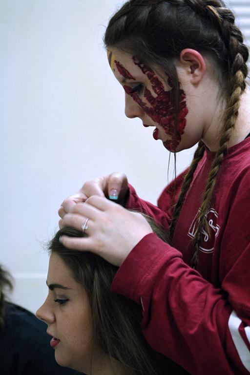 Kaelen Powless, radiology sophomore, preparing Meghan Myracle, education senior, to go out on stage for Lip Sync in Akin Auditorium. 24 Oct. Photo by Bridget Reilly