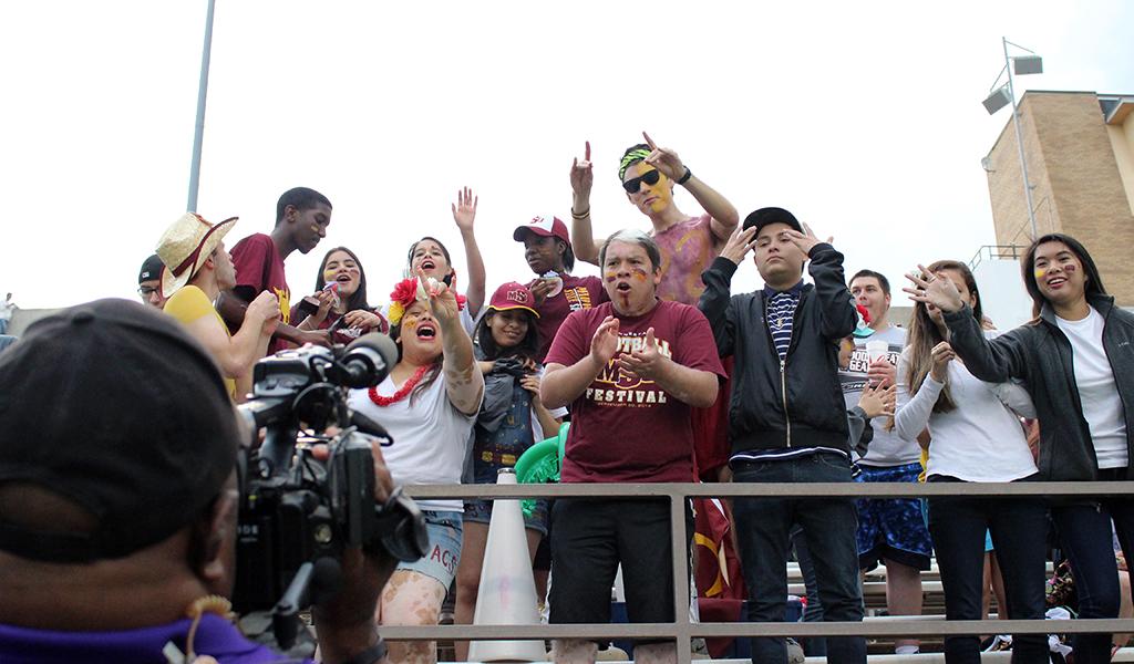 The Mustan Maniacs go wild for the camera to be on TV in the 2015 Maroon and Gold Spring game, Saturday April 18, 2015, which ended early due to a lightening sighting.  The first 1,000 fans to attend were given free tshirts, the Kiowa Cooks gave out free hot dogs, along with other bounce houses and free activites for kids. The Maroon team beat the Gold team 7-3. Photo by Rachel Johnson