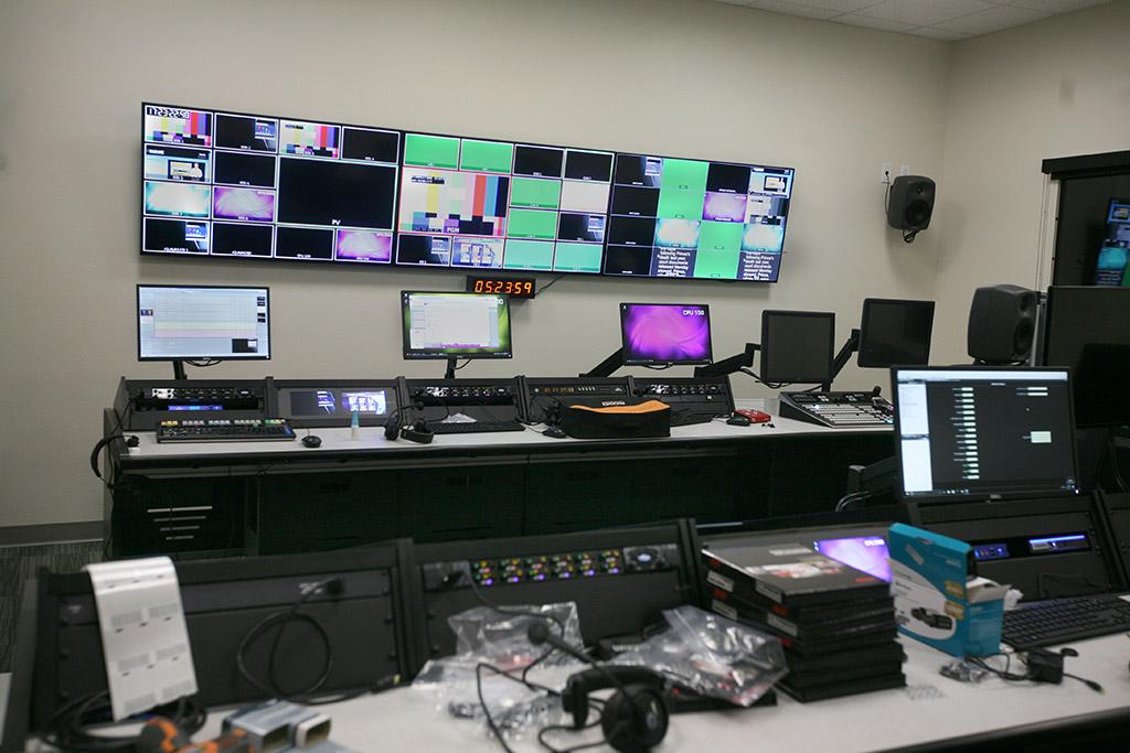 Many screens line the wall of the control room on the other side of the broadcasting studio on the first floor. Photo by Leah Bryce